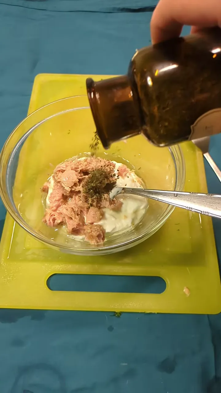 Greek yogurt being added to cucumber and tuna